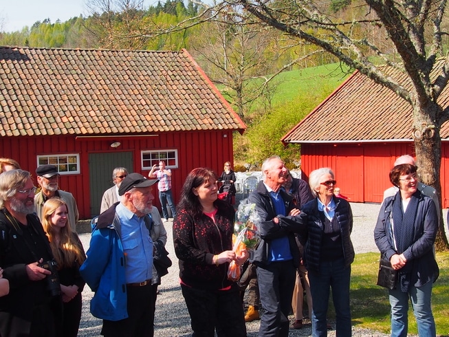 Mennesker utenfor røde hus