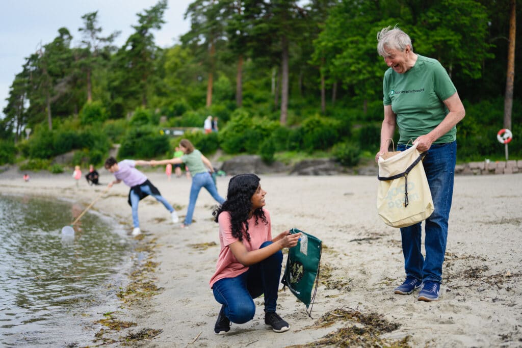 Mennesker som rydder stranden med Naturvernforbundet