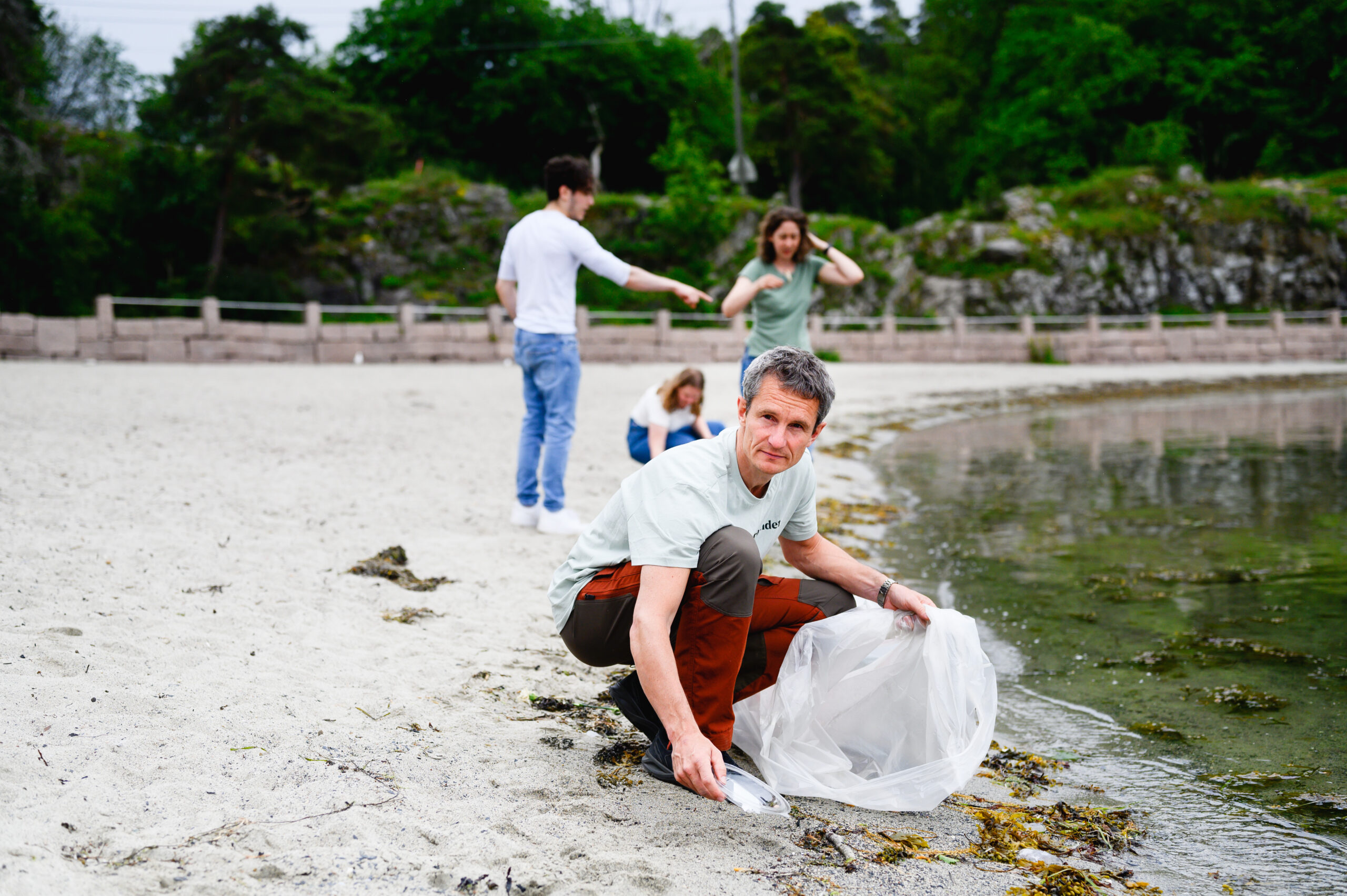 Lederen av Naturvernforbundet Truls Gulowsen og andre rydder stranden med Naturvernforbundet